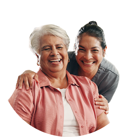 A senior woman and her caregiver joyfully embrace and laugh together. TITLE:
