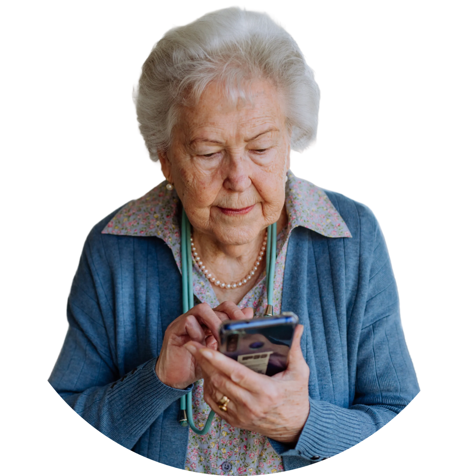 An elderly woman with white hair intently uses a smartphone, wearing a pearl necklace and a
