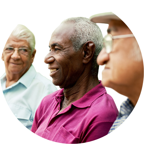 A diverse group of three smiling senior adults enjoying a conversation.