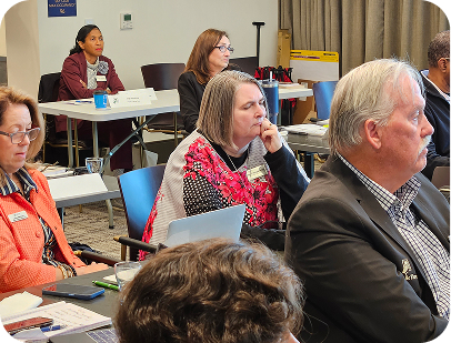 A diverse group of professionals intently listens during a conference or training session.