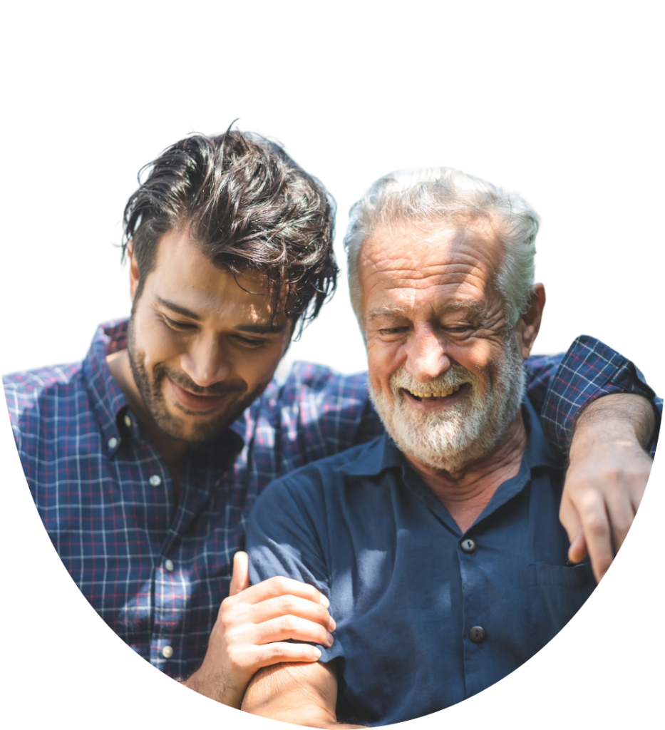 A younger man embraces an older man with a grey beard, both smiling warmly. TITLE: