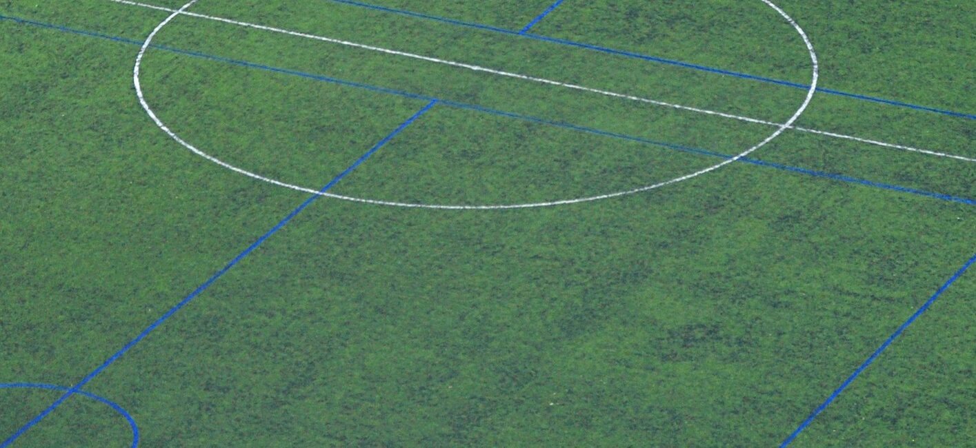 A soccer field with a goal post and the markings for the ball.