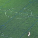 A soccer field with a goal post and the markings for the ball.