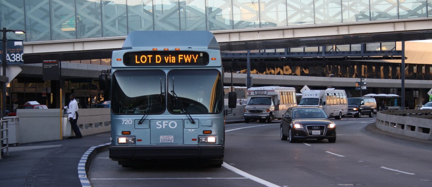 A bus driving down the street with cars on it.