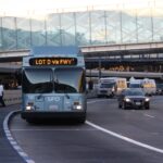 A bus driving down the street with cars on it.