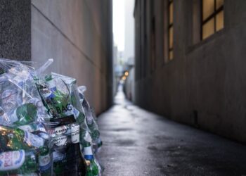 A bottle of water is sitting on the side walk