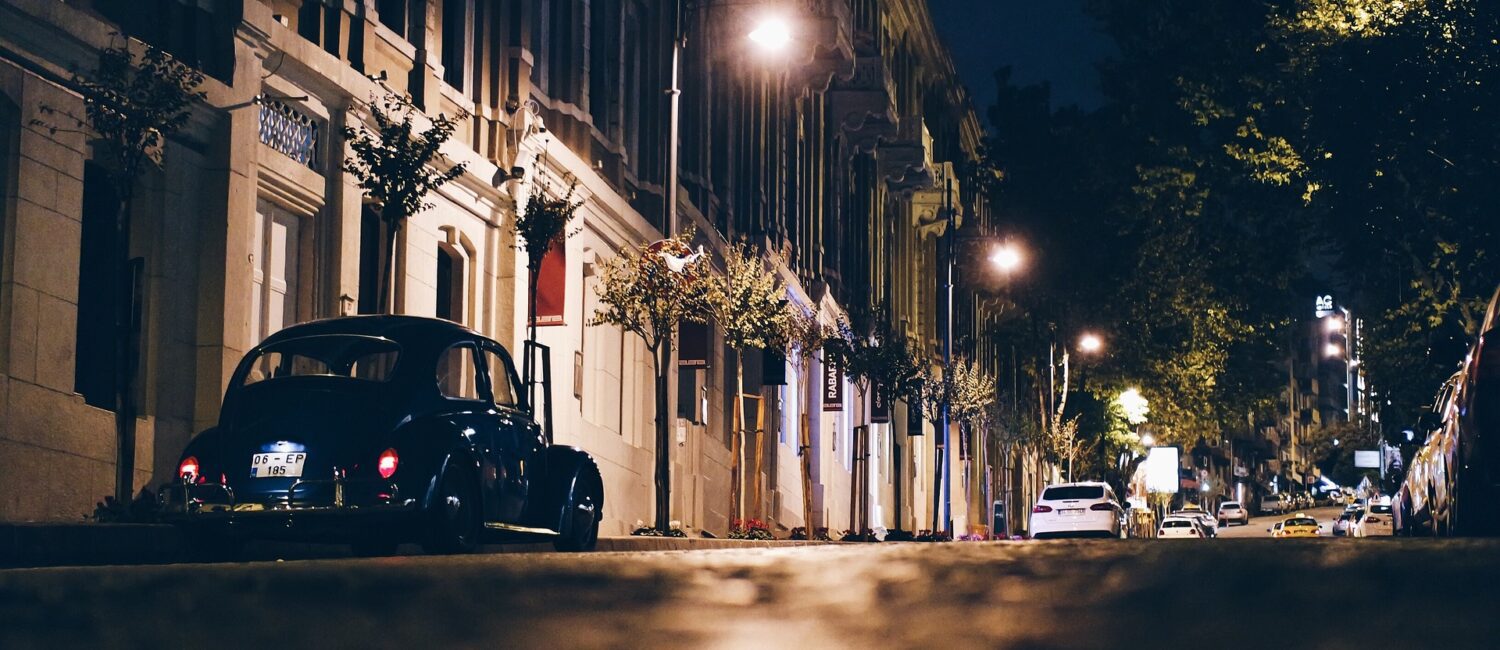 A car parked on the side of a street at night.