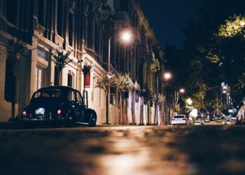 A car parked on the side of a street at night.