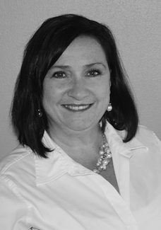 A black and white photo of a woman smiling.