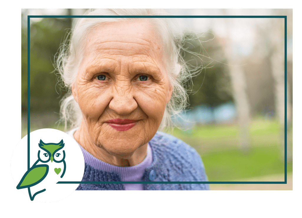 An old woman with a owl sticker on her face.