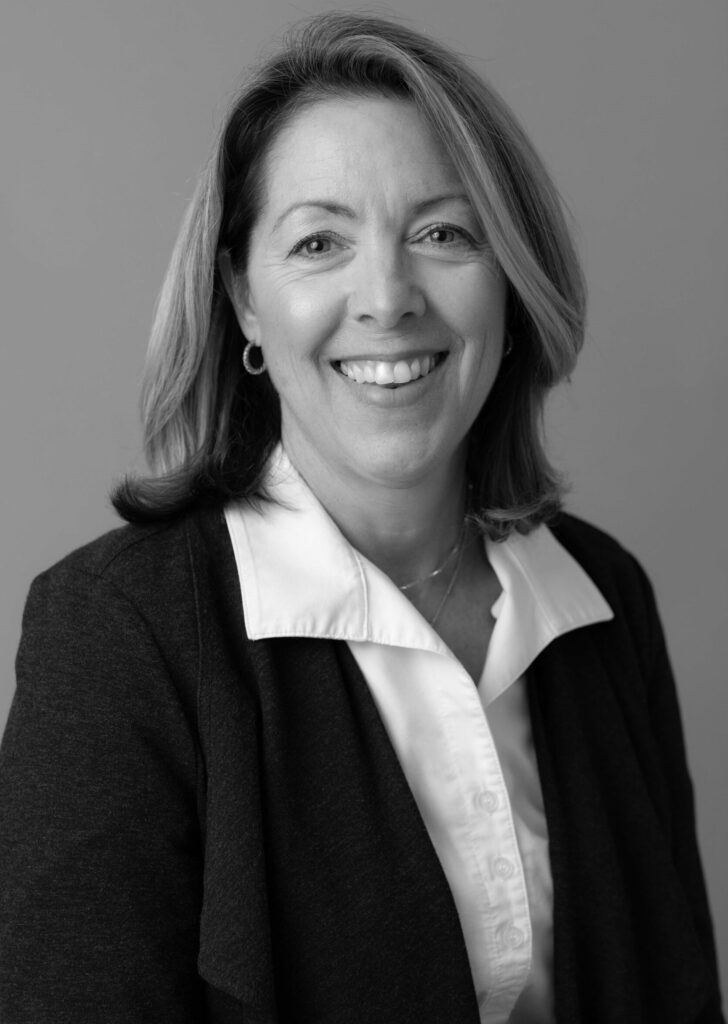 A black and white photo of a woman smiling.