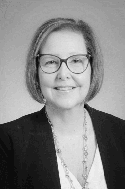 A black and white photo of a woman wearing glasses.