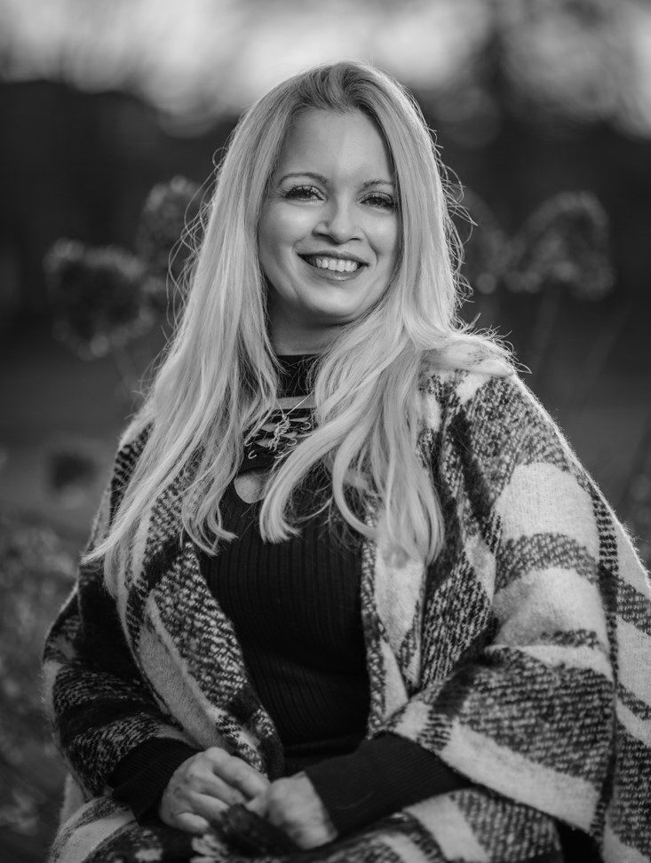 A woman in black shirt and white jacket