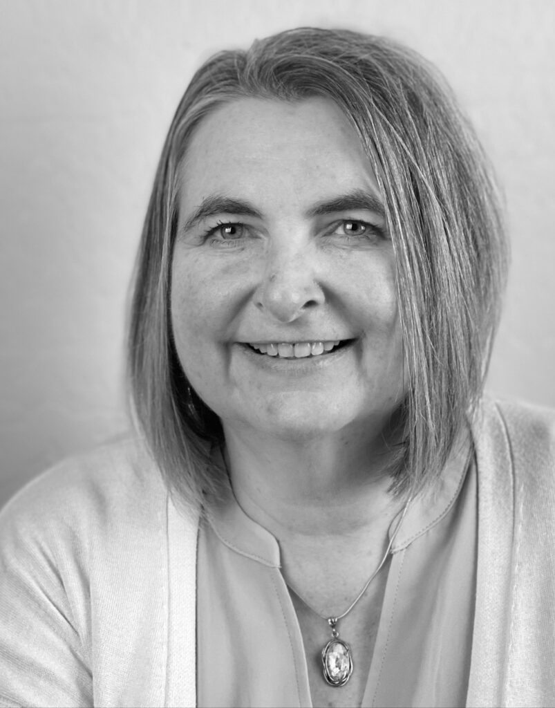 A black and white photo of a woman smiling.