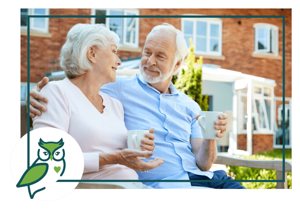 An older couple sitting on a bench with coffee.