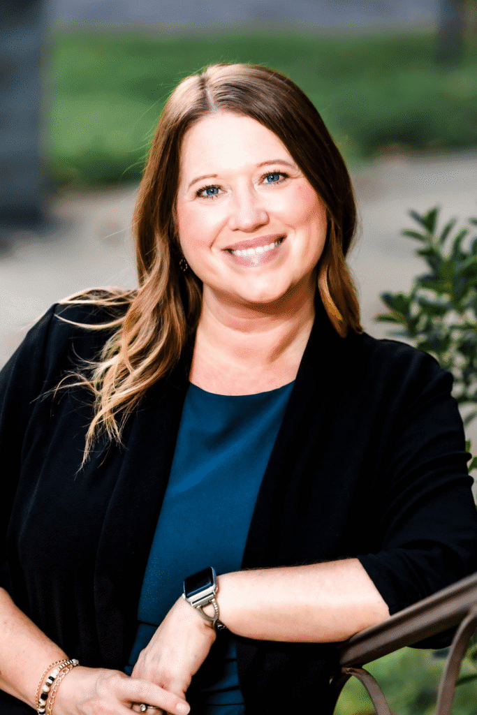 Smiling woman sitting outdoors on bench.